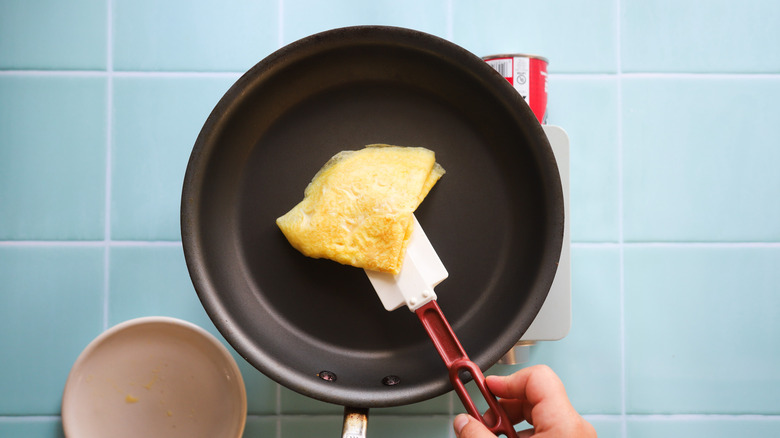 Folded scrambled eggs in pan