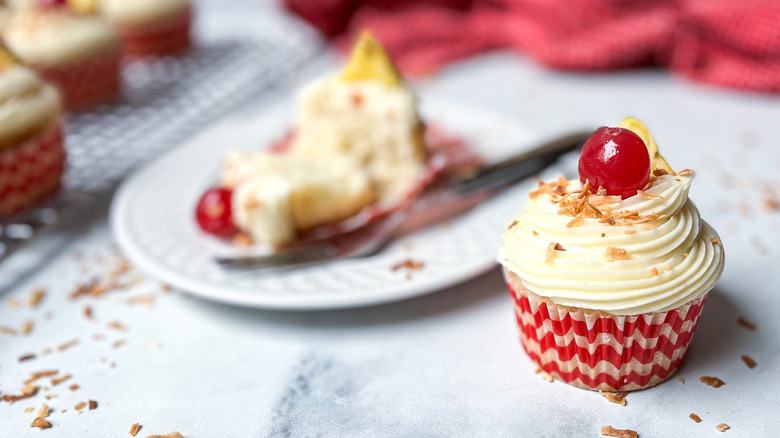 white-frosted cupcake with cherry