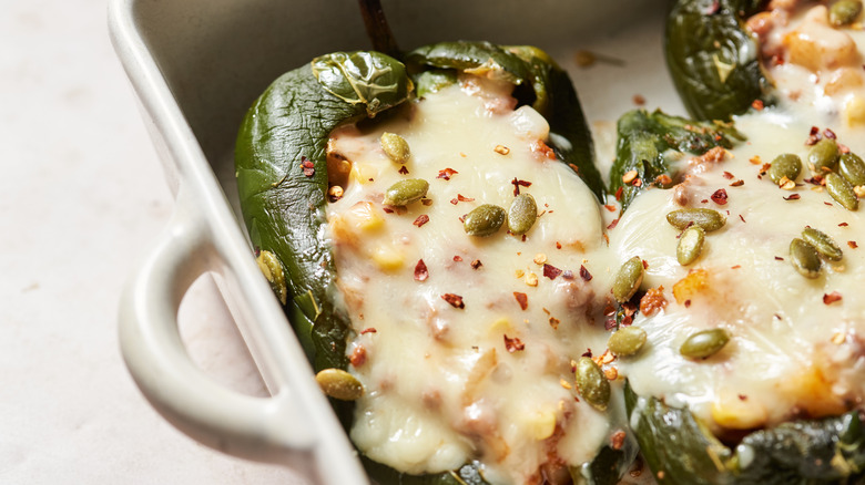 stuffed peppers with melted cheese in baking dish