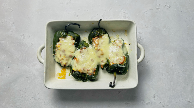 stuffed peppers with melted cheese in baking dish