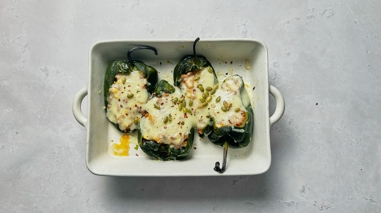 stuffed peppers with melted cheese in baking dish