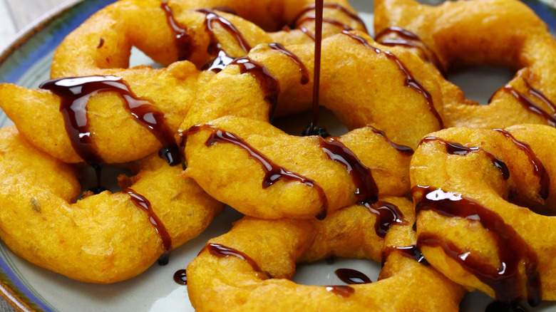 chancaca syrup drizzled on picarones