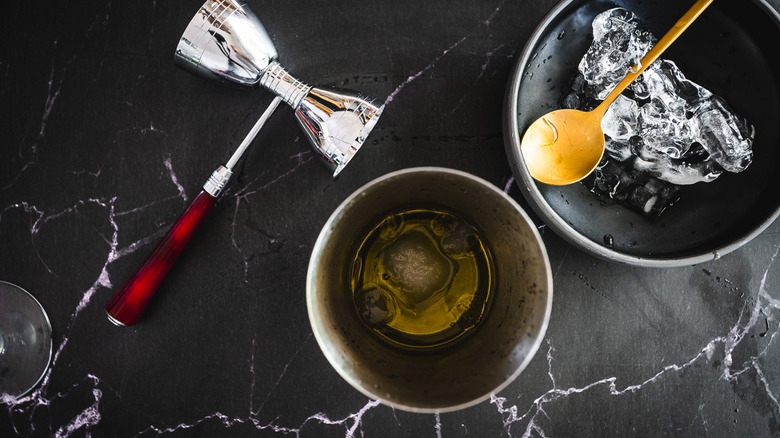 cocktail ingredients in shaker, jigger, and ice