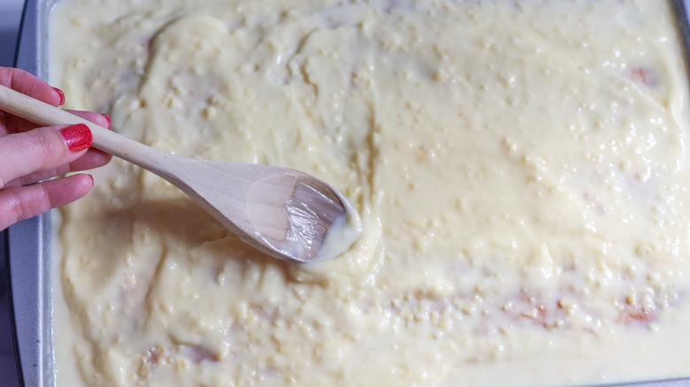 spreading pudding over poke cake