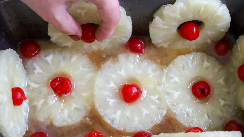 hand putting pineapple in pan