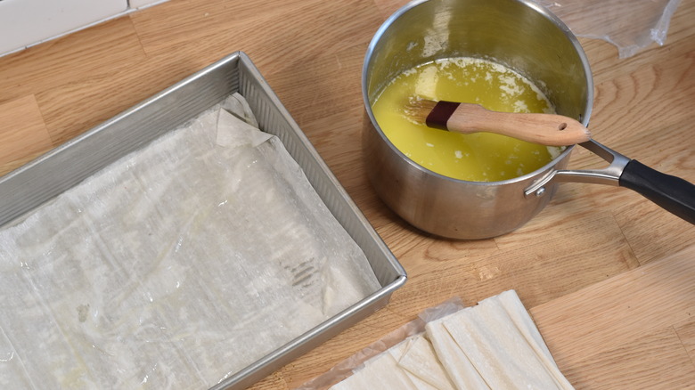 brushing butter on phyllo dough, melted butter in pot