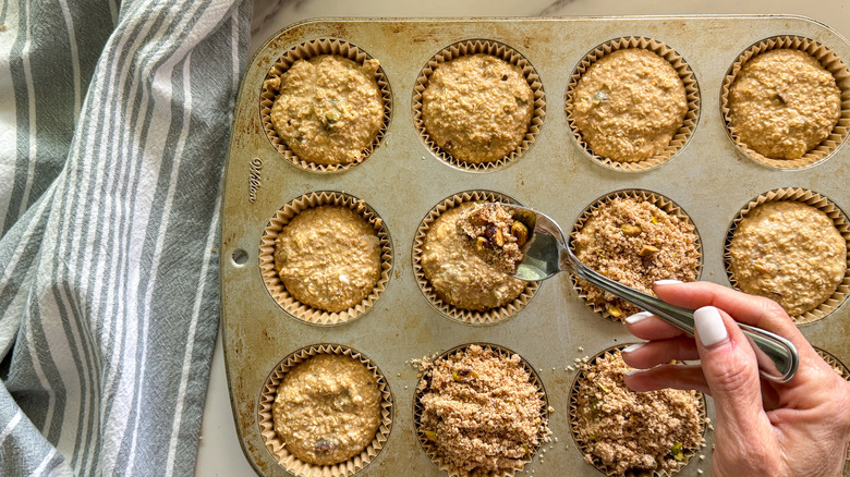 hand with spoon adding crumble