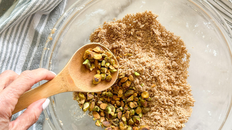 hand adding pistachio pieces