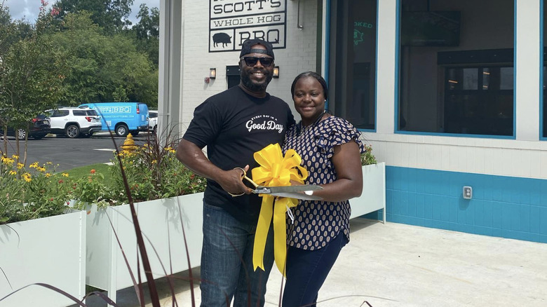 Rodney Scott holding scissors and ribbon