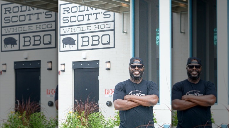 Rodney Scott posing in front of restaurant