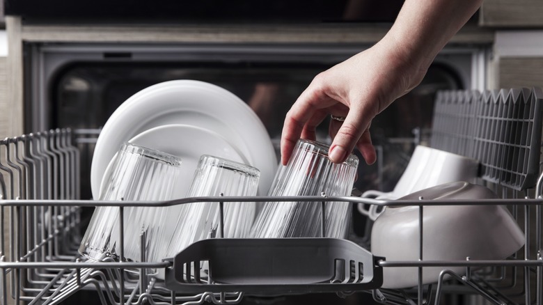 Hand loading dishes in a dishwasher