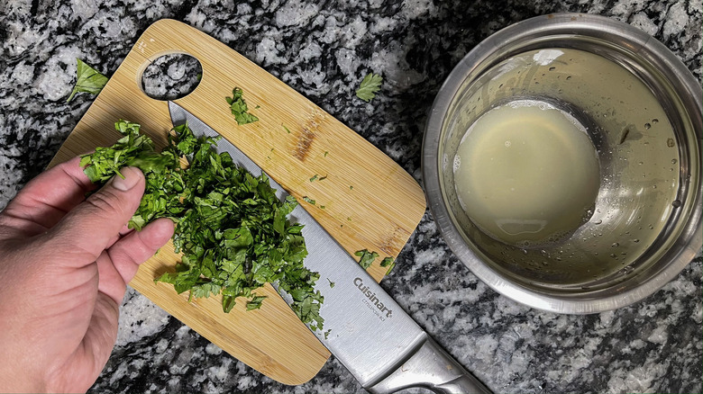 chopping cilantro near bowl of lime juice