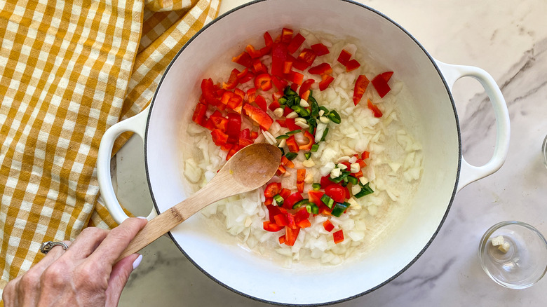 Hand stirring vegetables in pot