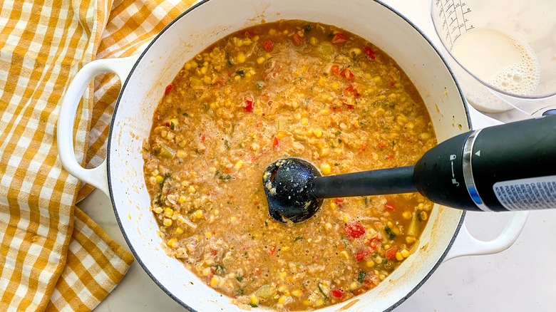 Immersion blender in pot of corn chowder