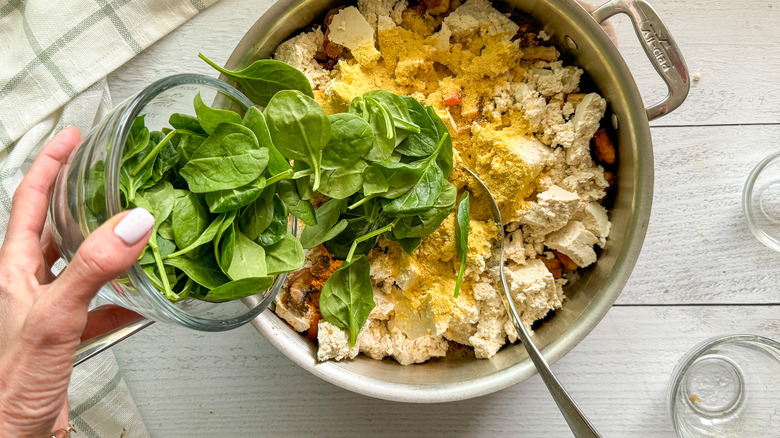 adding spinach to pan