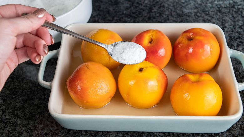 sprinkling vanilla sugar over peaches