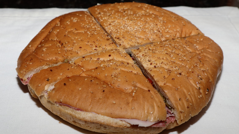 Muffuletta bread cut in quarters