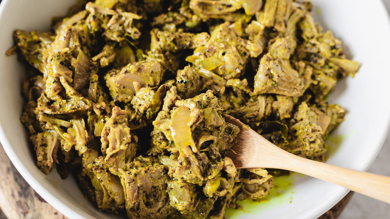 Bowl of jackfruit curry with wooden spoon