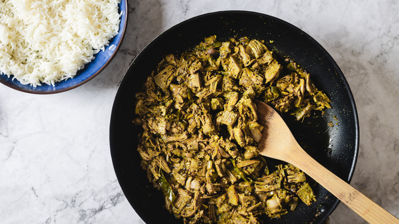 Pan of jackfruit curry besides rice