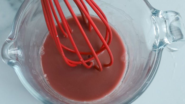 whisking pomegranate juice in cup