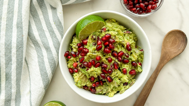Guacamole with pomegranate seeds and lime