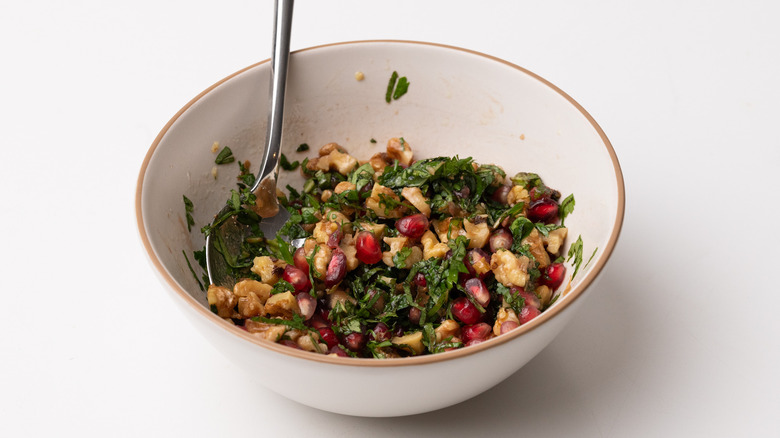 pomegranate and walnut salsa in white bowl