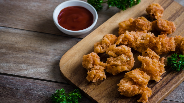 popcorn chicken on serving board beside dip