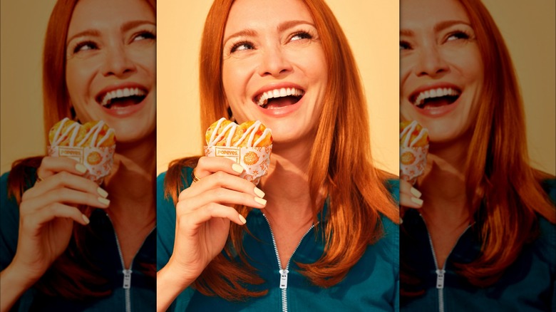 woman eating Popeyes strawberry biscuit