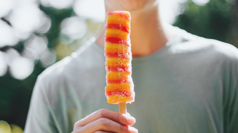 Person holding a striped popsicle