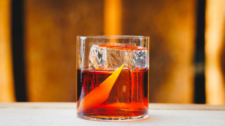 A negroni served in a highball glass with an orange twist