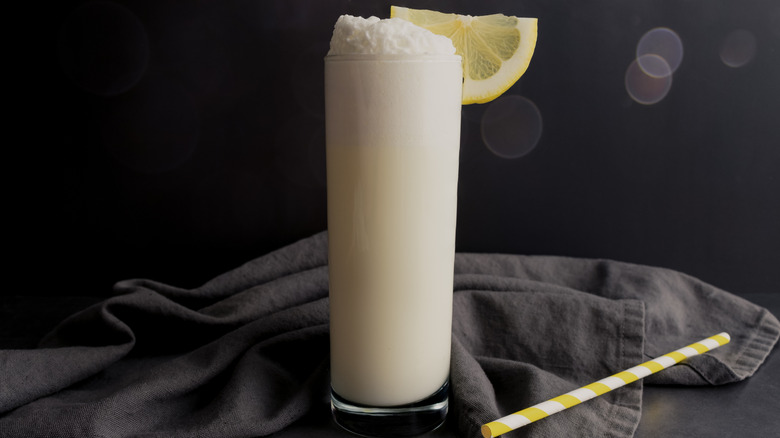 Ramos gin fizz cocktail garnished with lemon