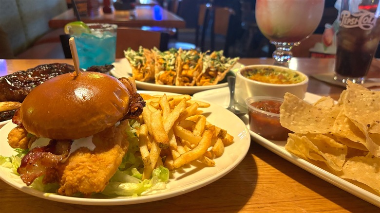 Four Applebees dishes, cocktails and soda on table in restaurant