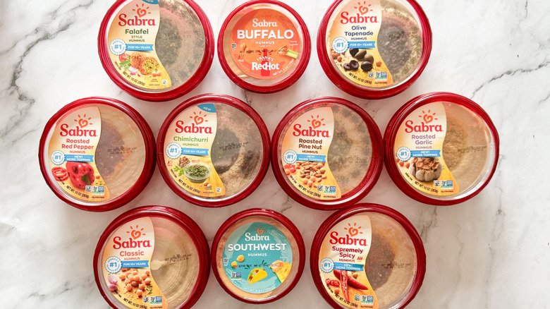 10 Sabra hummus containers on marble surface