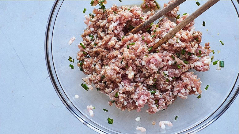 mixing the pork filling with chopsticks