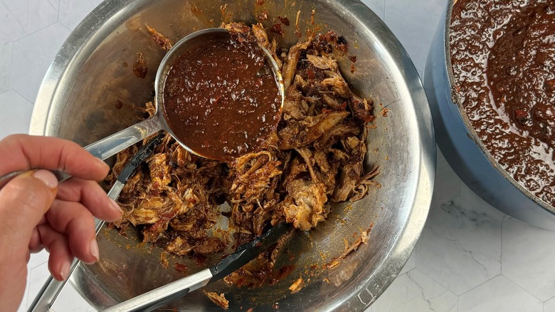 hand pouring sauce onto pork