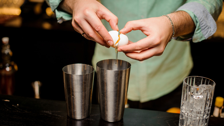 Breaking egg into cocktail shaker 