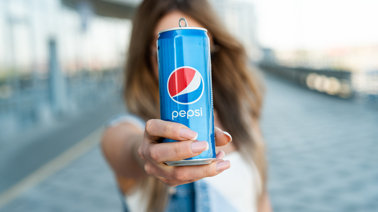 Person holding a Pepsi can