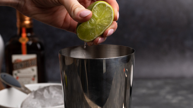 squeezing lime into cocktail shaker