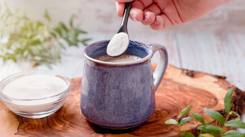 woman spooning protein in coffee