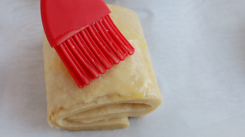 silicone brush on unbaked croissant