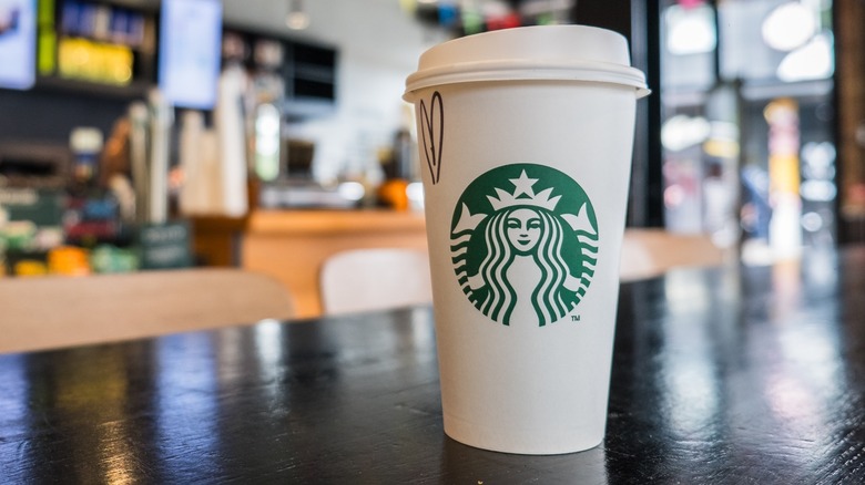 A branded paper Starbucks cup on a counter