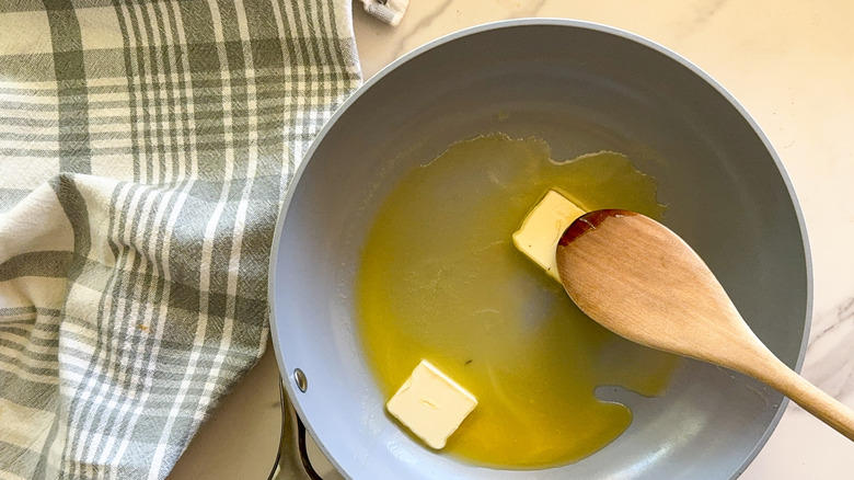 hand stirring butter in pan