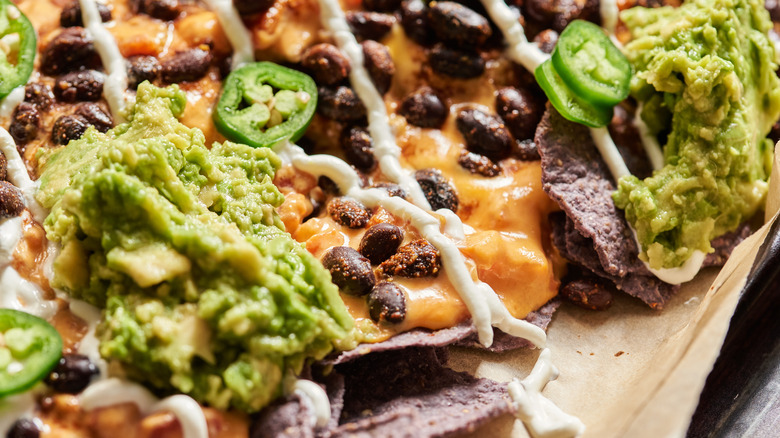 black beans and avocado on top of nachos