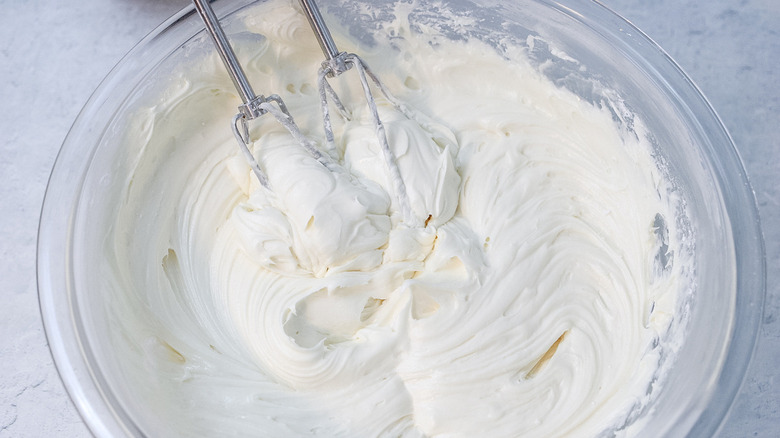 mixing white frosting in bowl