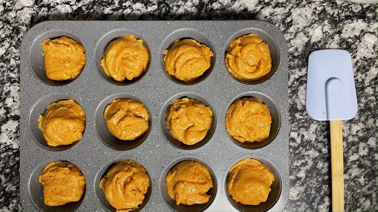 muffin tin with pumpkin batter