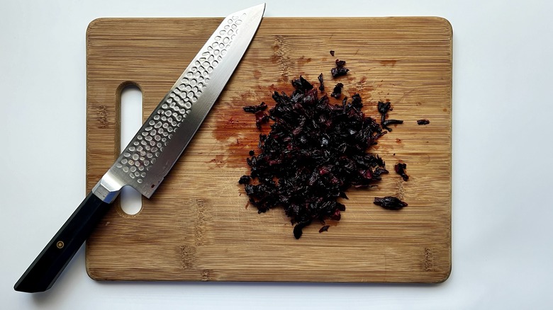 chopping hibiscus petals on board