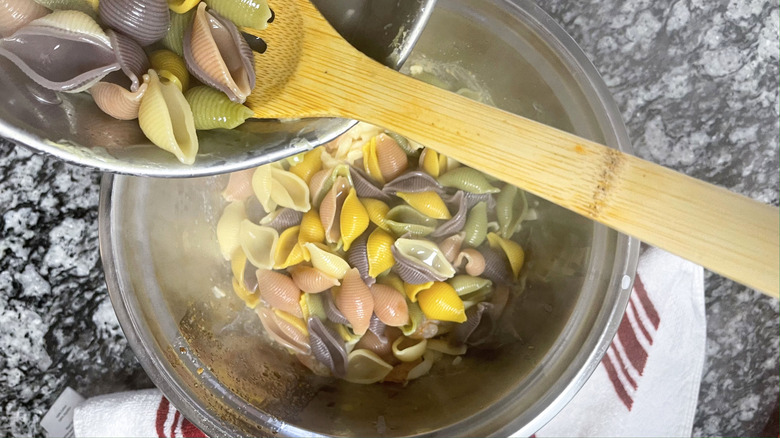 pouring pasta into bowl
