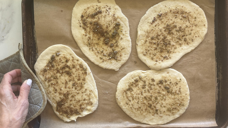 four slices of unbaked bread on a baking sheet