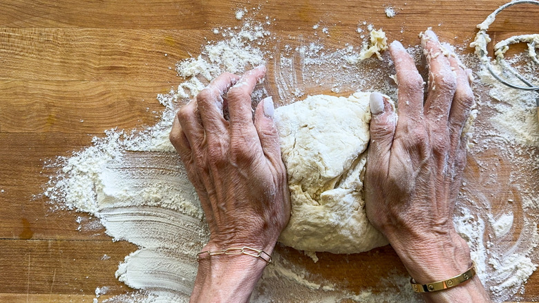 Hands kneading dough on a counter