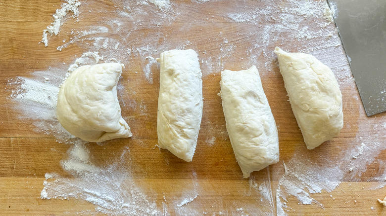 Four pieces of dough on a floured counter